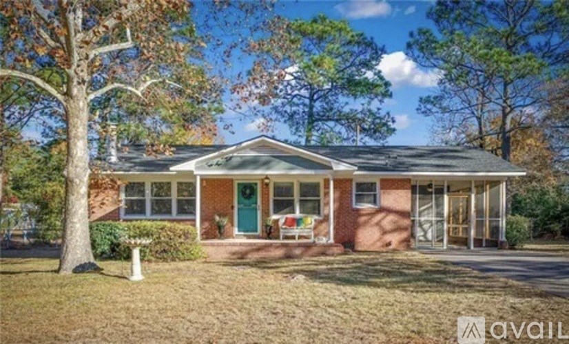 A house with a green door and a tree in front.