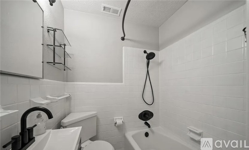 A bathroom with a white tub, sink, and toilet.