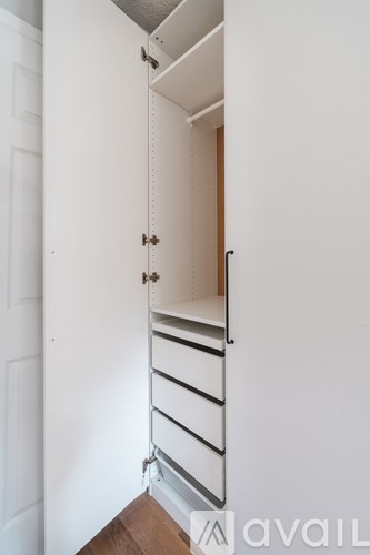 A white door with a white wall and a white shelf.