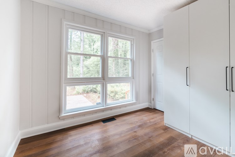 A room with a window and wooden floors.