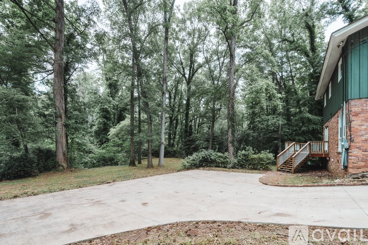 A house with a green door stands in a wooded area.
