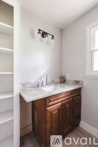 A bathroom with a sink and a shower head.