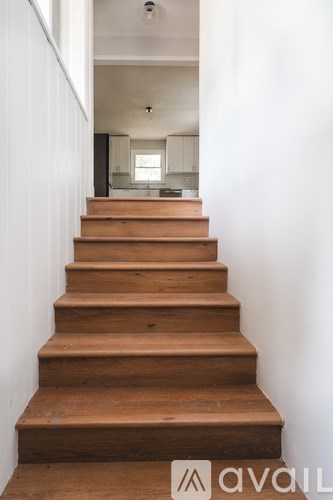 A set of wooden stairs leading to a bright room.