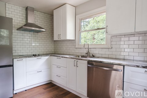 A kitchen with white cabinets and a stainless steel dishwasher.
