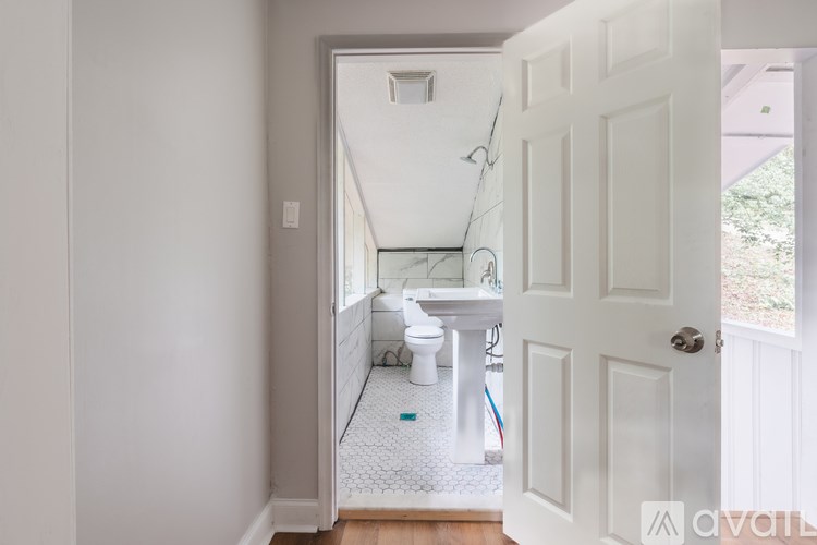 A bathroom with a toilet, sink, and a white door.