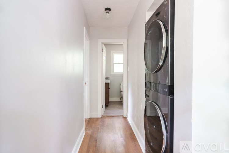 A narrow hallway with a washing machine on the side.