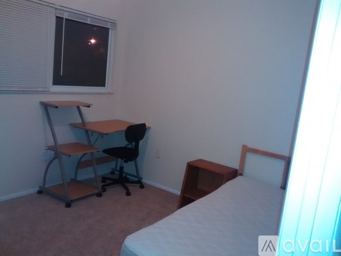 A bedroom with a bed, desk, and chair.