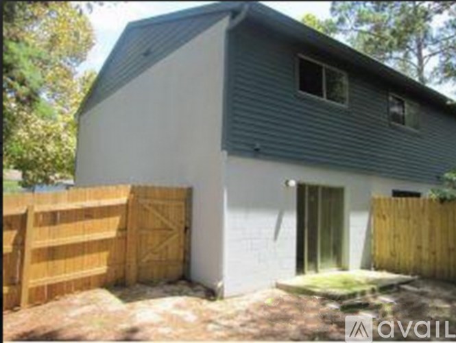 A house with a grey roof and a wooden fence.
