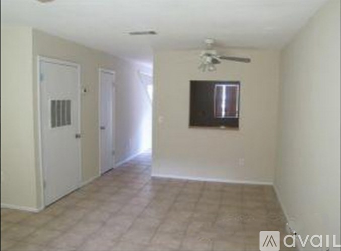 A room with a ceiling fan and a small window.