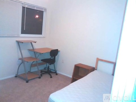 A bedroom with a bed, desk, and chair.
