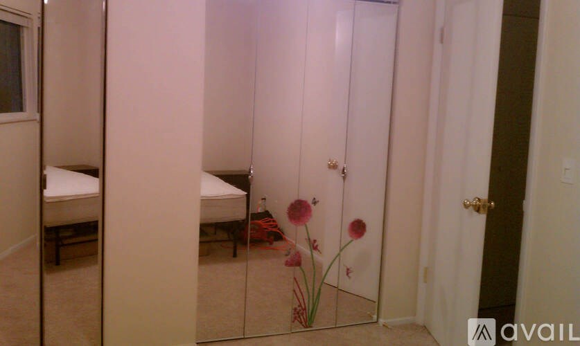 A room with a bed and a mirror with flowers on it.