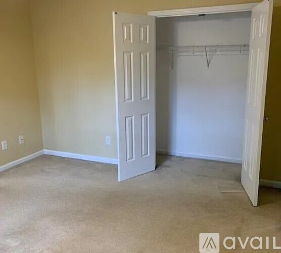 A room with a white door and a coat rack.