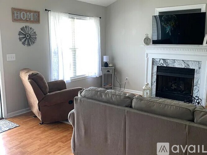A living room with a fireplace, a couch, and a chair.