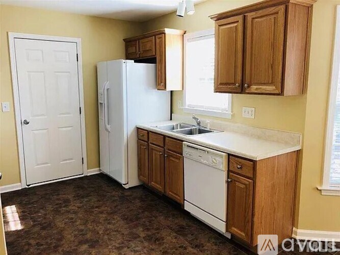 A kitchen with white appliances and wooden cabinets.