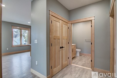 A wooden door is open to a bathroom.