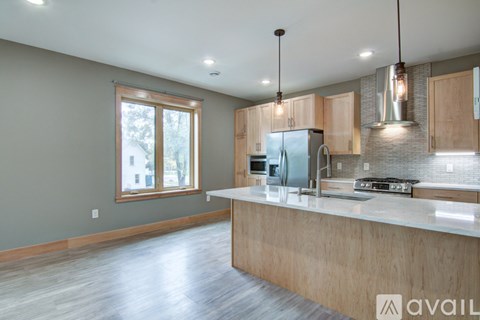 A modern kitchen with wooden cabinets and a large island.