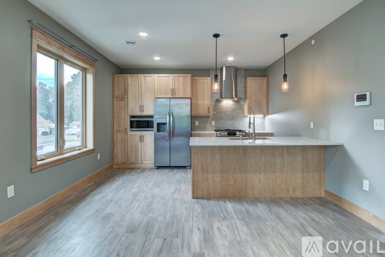 A modern kitchen with wooden cabinets and a large island.