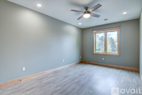 A room with a ceiling fan and a window.