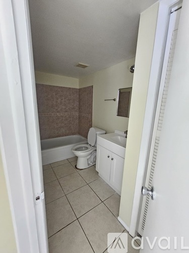 A bathroom with a toilet, sink, and bathtub.