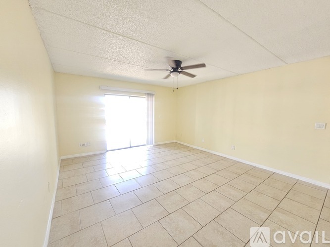 A room with a ceiling fan and tiled floor.