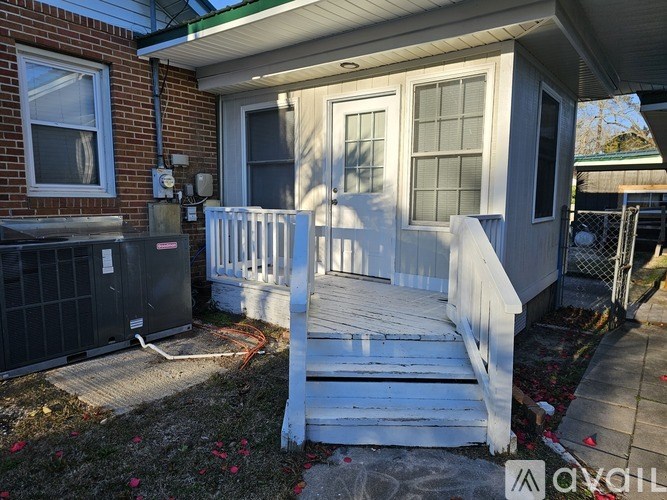 A house with a white porch and a brick wall.