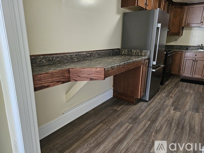 A kitchen with a refrigerator, oven, and cabinets.
