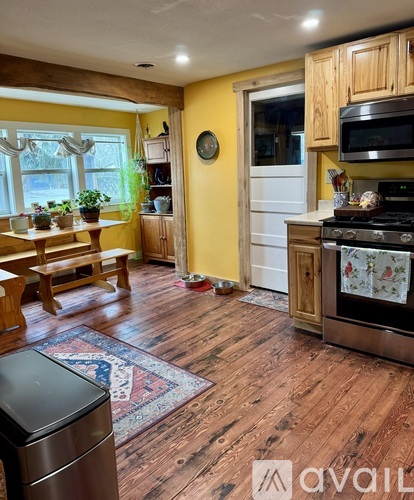 A kitchen with wooden floors and a stove top oven.