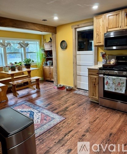 A kitchen with wooden floors and a stove top oven.