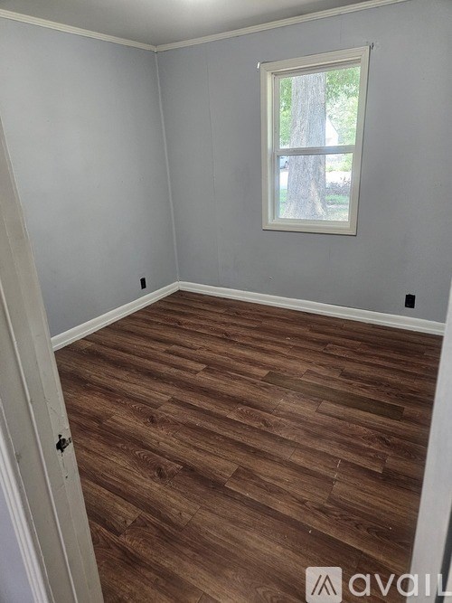 A room with wooden flooring and a window.