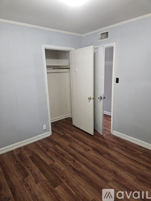 A room with a white door and a white closet with a white shelf.