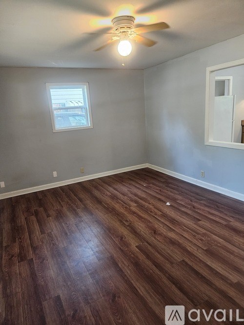 A room with wooden flooring and a ceiling fan.