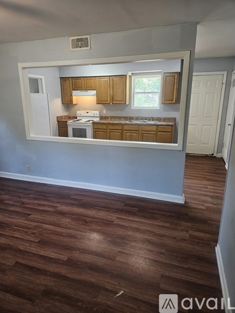 A kitchen with wooden cabinets and a white fridge.