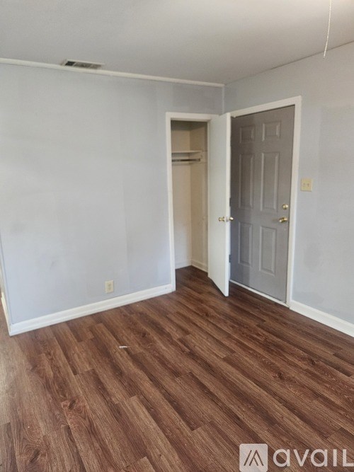 A room with wooden flooring and a white door.