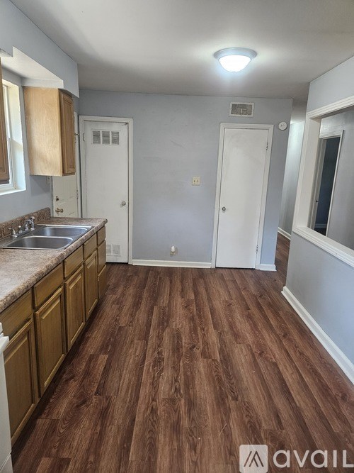 A kitchen with wooden floors and white walls.