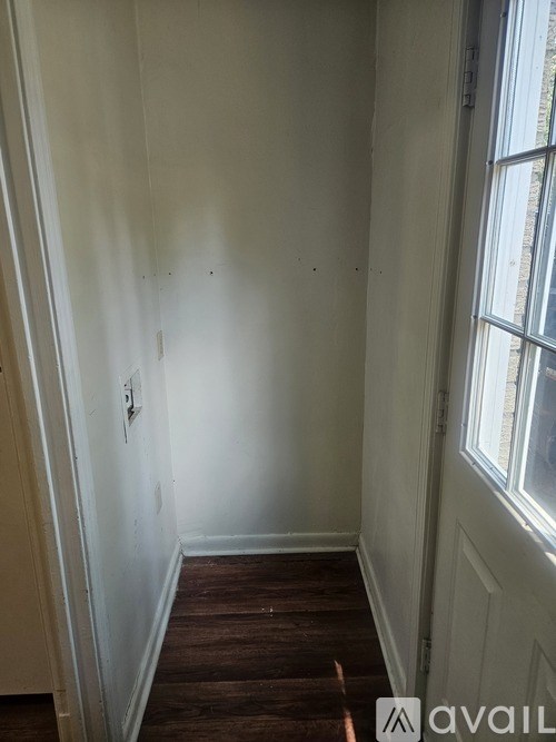 A room with a window and wooden floor.