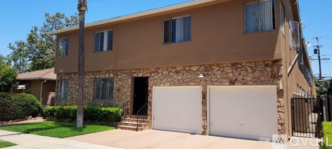 A two-story house with a stone facade and a white garage door.