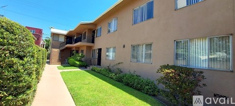 A beige apartment building with a green lawn in front.