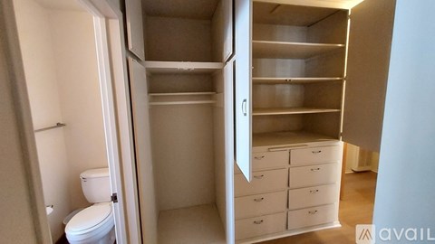 A bathroom with a toilet and a cabinet with drawers is shown.