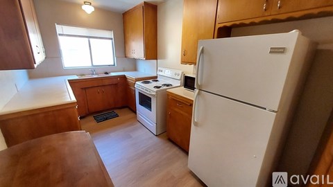 A kitchen with wooden cabinets and a white refrigerator.