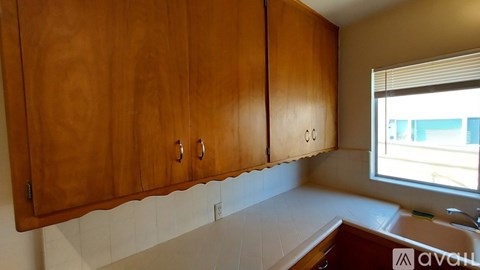 A kitchen with wooden cabinets and a window.