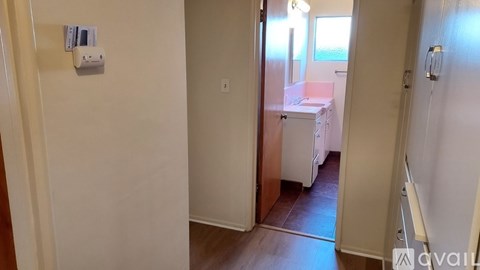 A room with a white door and a white wall with a switchboard.