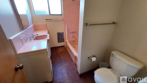 A bathroom with a toilet, sink, and bathtub.