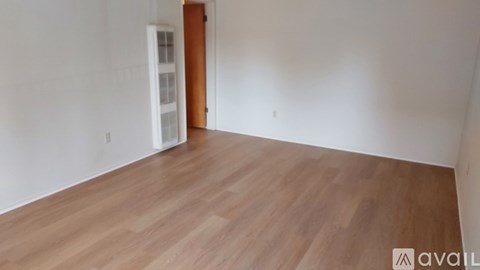 A room with wooden flooring and a white door.