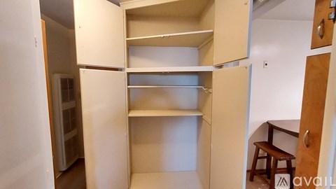 A small, empty kitchen with a wooden door and a white wall.