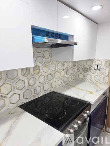 A kitchen with a black stove top oven and white cabinets.