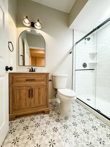 A bathroom with a toilet, sink, and mirror.
