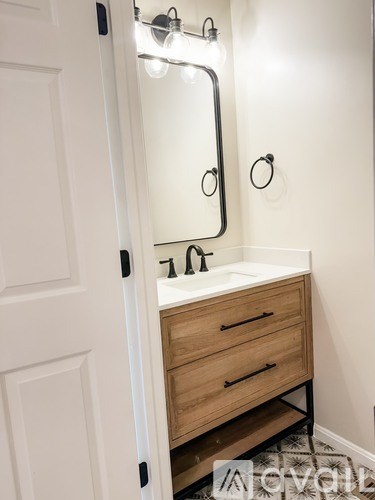 A white bathroom with a sink and a mirror.