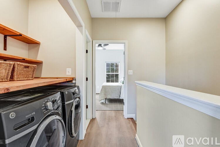 A room with wooden floors and three windows looking out to a street.
