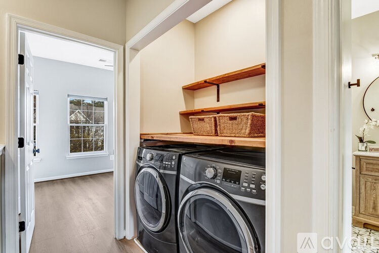 A room with three windows and wooden floors.