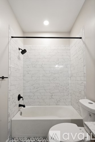 A white bathroom with a tub, toilet and sink.